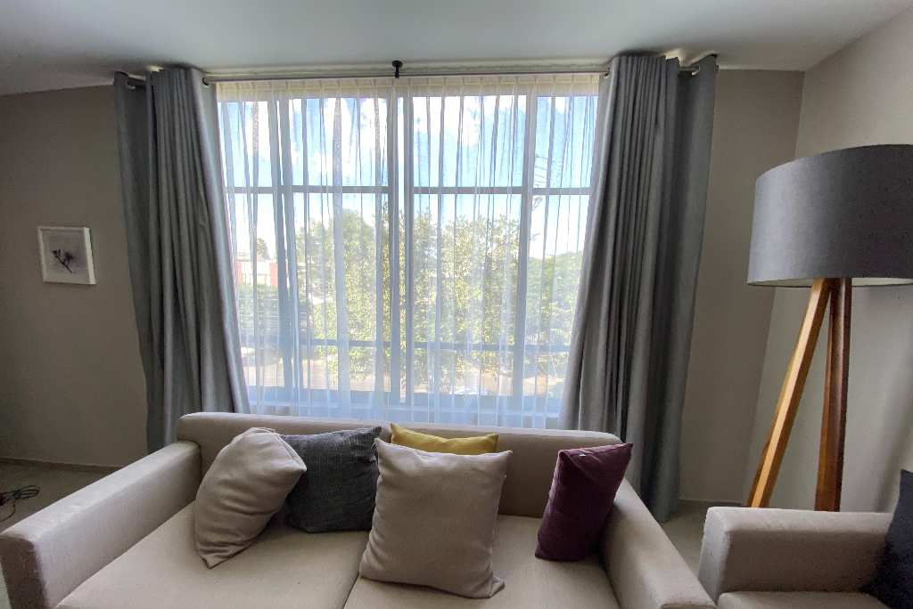 combinación de cortinas ojal blackout y tergal translúcido, para una sala moderna en zapopan