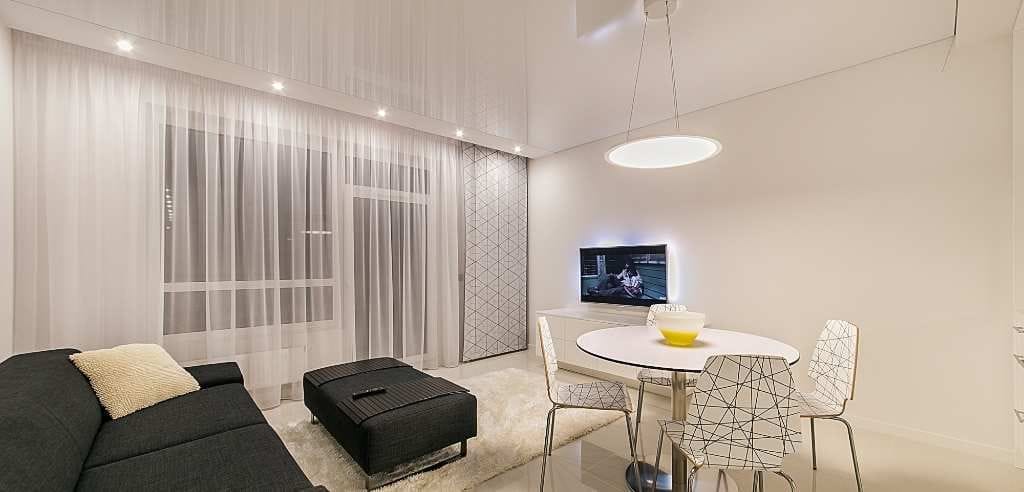 Una sala de estar minimalista con cortinas modernas transparentes creando un aspecto elegante y limpio en el espacio. 