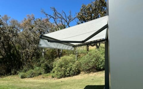 un toldo de proyeccion color gris con brazos extendidos y automatizado