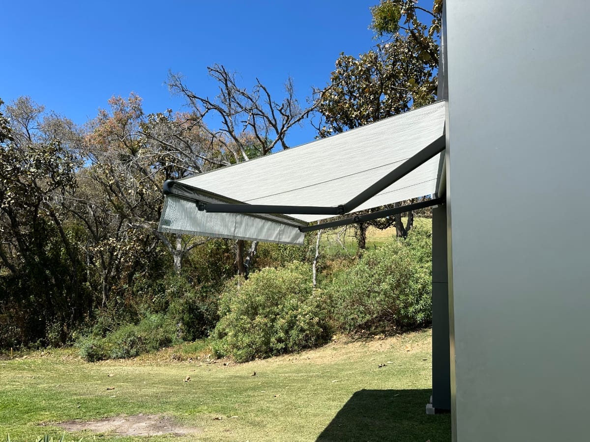 un toldo de proyeccion color gris con brazos extendidos y automatizado